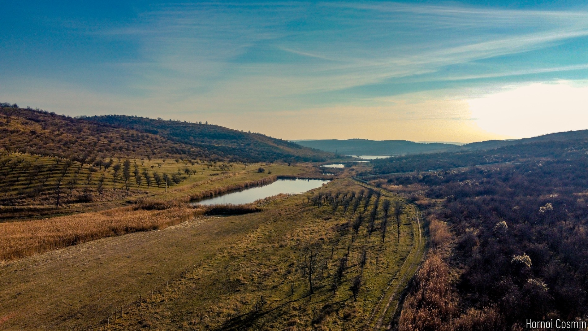 Livada și lacul văzute din dronă la apus