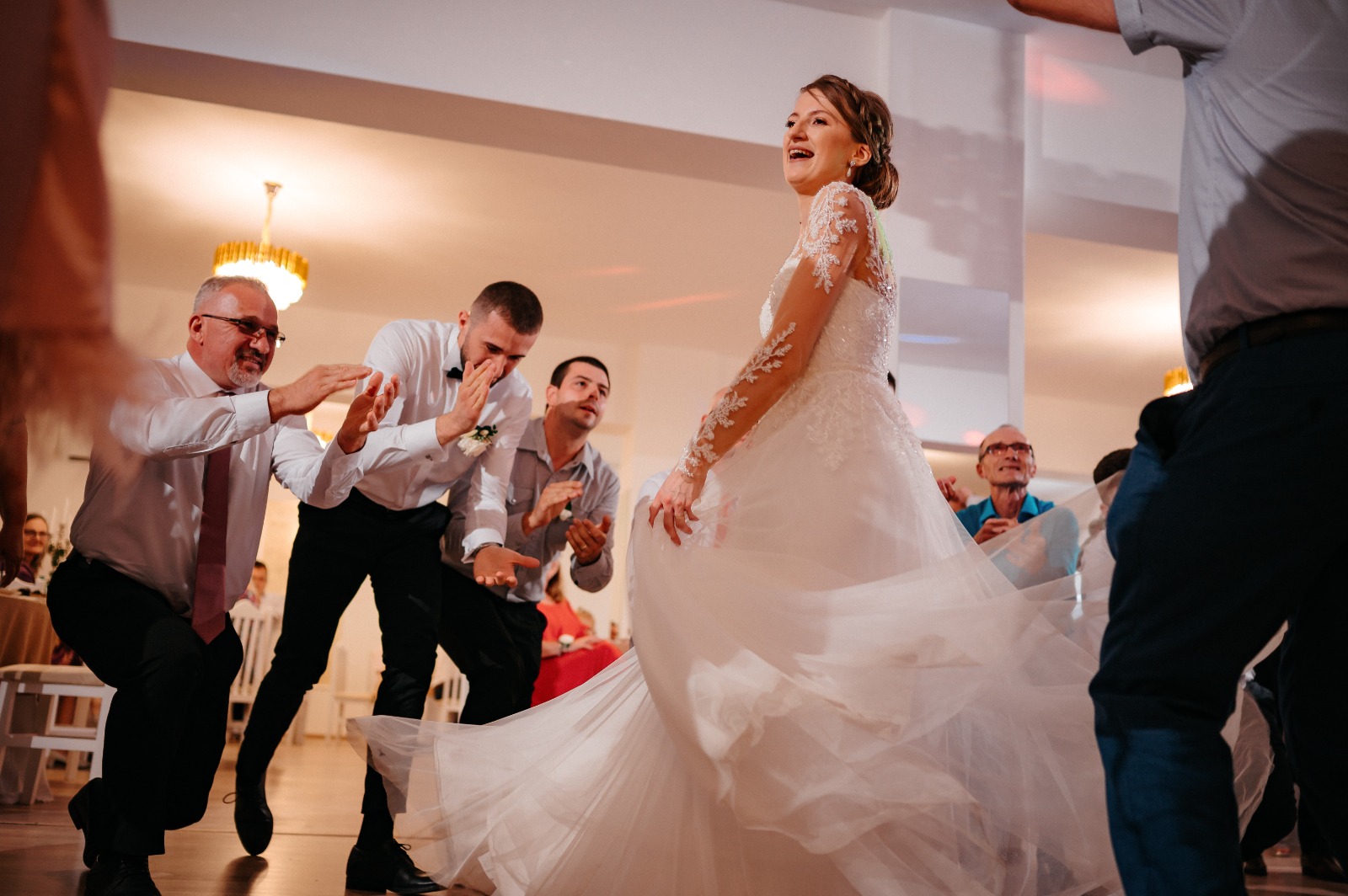 Mireasă dansând, înconjurată de invitați