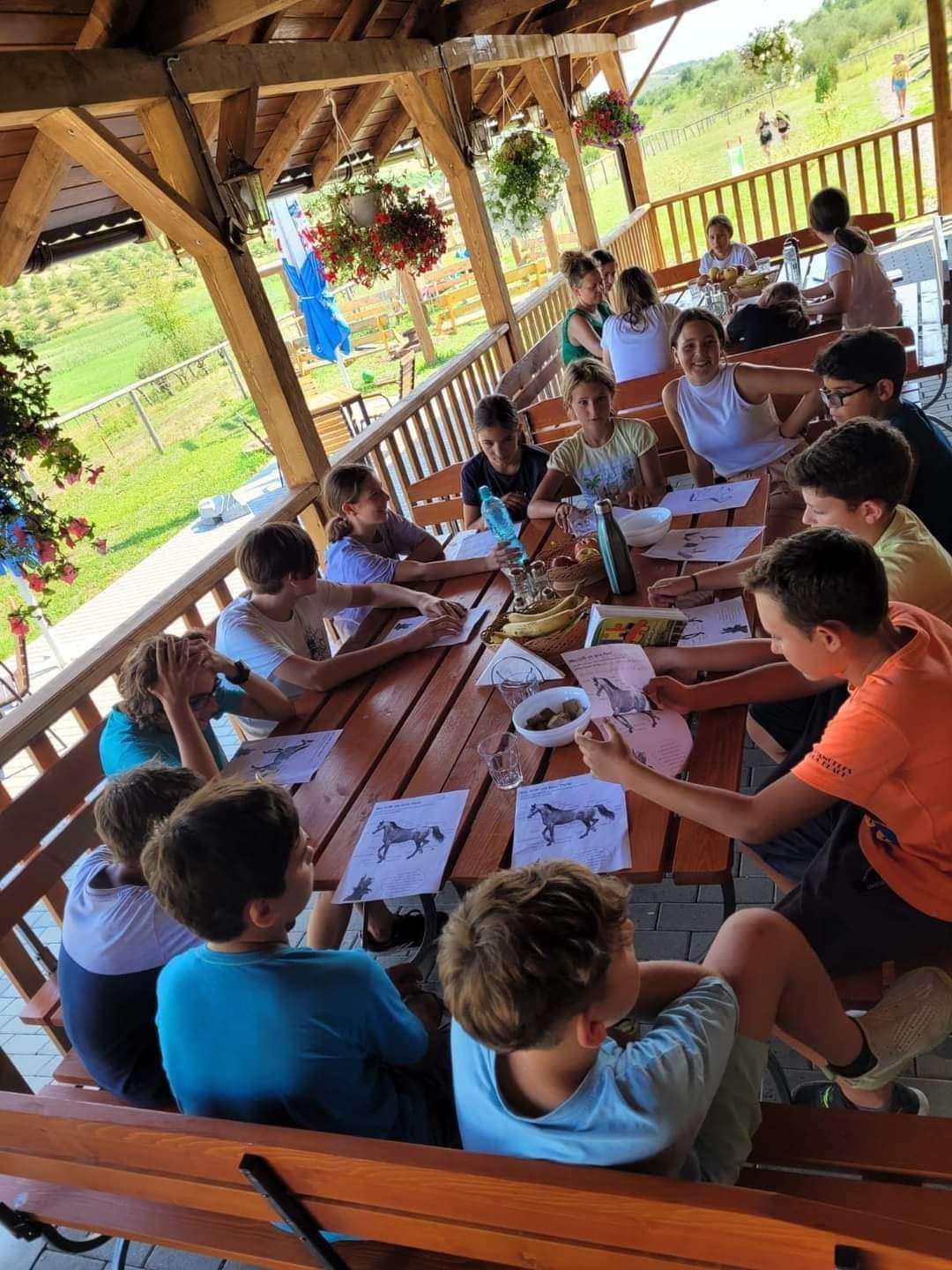 Copii la un atelier, la masa din foișor